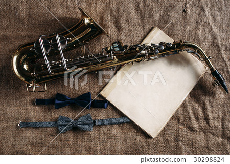 Saxophone, notes and bowtie on canvas background Saxophone, notes and bowtie on canvas background 30298824