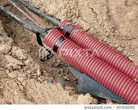 Excavation of trench with black cable in HDPE tube 30308090