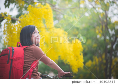 Beautiful Asian girl with red backpack riding bicy 30308841
