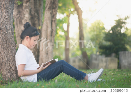 Asian Girl reading a book under the tree Asian Girl reading a book under the tree 30309043