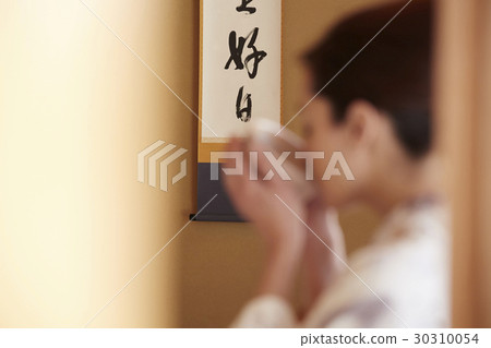 A woman enjoying a tea ceremony A woman enjoying a tea ceremony 30310054
