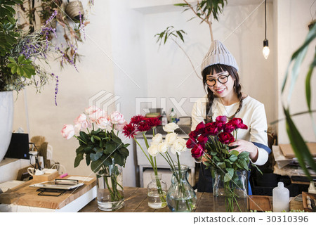Female staff in a flower shop Female staff in a flower shop 30310396