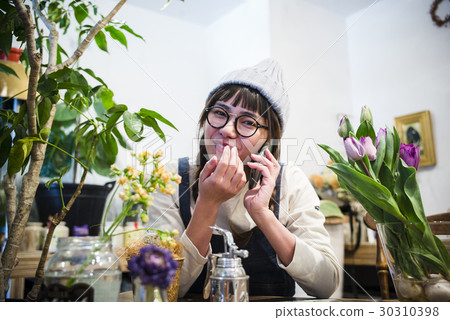 Female staff in a flower shop Female staff in a flower shop 30310398