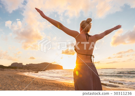 Free Happy Woman Enjoying Sunset on Sandy Beach 30311236