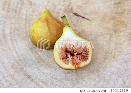Fig cut open showing the flesh wooden background. 30311519