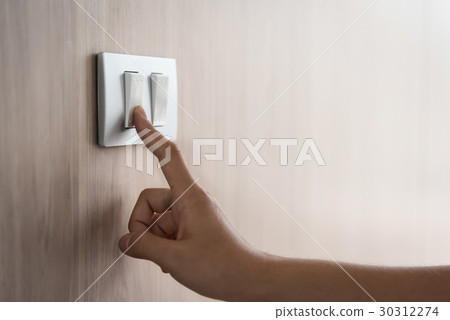 hand turning on or off on grey light switch 30312274
