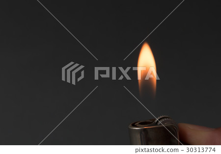 Hand igniting fire with lighter on dark background 30313774