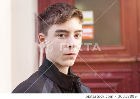 portrait of a young man in front of a red door portrait of a young man in front of a red door 30318899