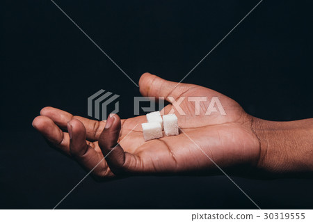Cubes of white sugar on black man palm, closeup Cubes of white sugar on black man palm, closeup 30319555