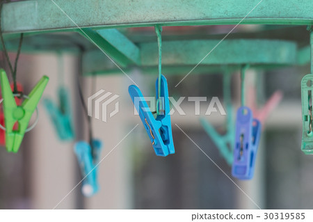 Clothes pegs or clothespins hang on a cord Clothes pegs or clothespins hang on a cord 30319585