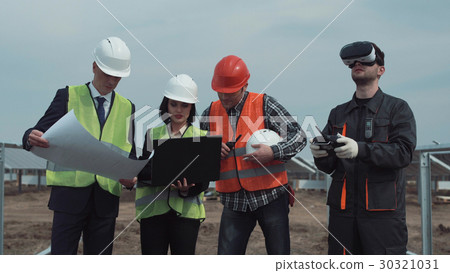 Man controlling drone during discussion on solar Man controlling drone during discussion on solar 30321031