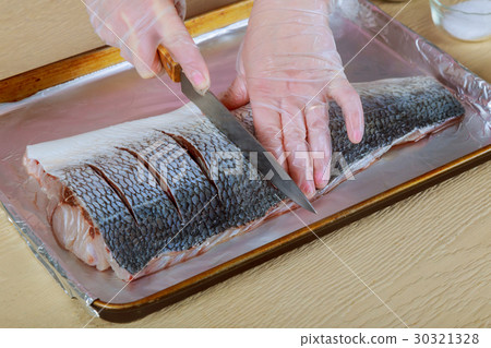 Woman cooking raw fish on kitchen Woman cooking raw fish on kitchen 30321328