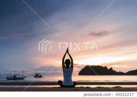Woman practicing yoga on the beach at sunset. Woman practicing yoga on the beach at sunset. 30322217