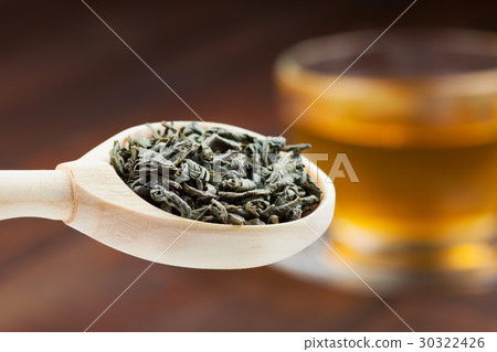 green tea leaves in wooden spoon, cup of tea 30322426