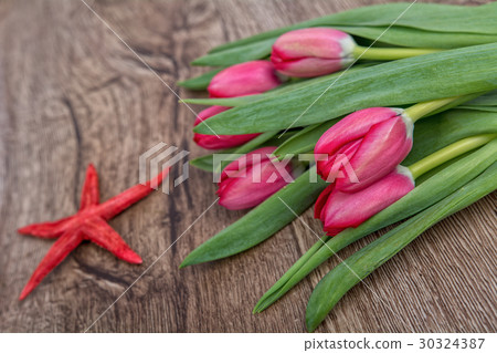 Starfish and tulips on a wooden background Starfish and tulips on a wooden background 30324387
