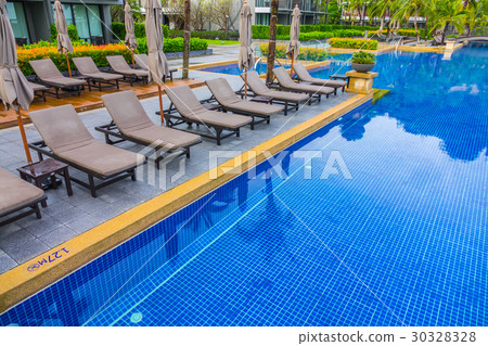 Swimming pool with relaxing seats near the sea . Swimming pool with relaxing seats near the sea . 30328328
