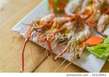 shrimps grilled served in plate on wood table . shrimps grilled served in plate on wood table . 30328662