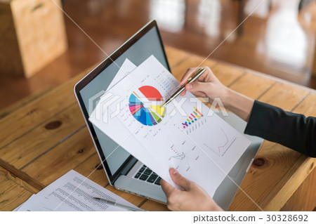 Business woman hand with Financial charts and laptop on the table . 30328692