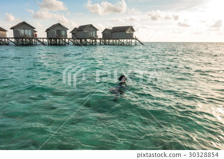 Beautiful tropical Maldives resort hotel with beach and blue water. 30328854