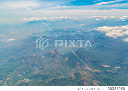 Mountains under clouds. View from the airplane . 30328960