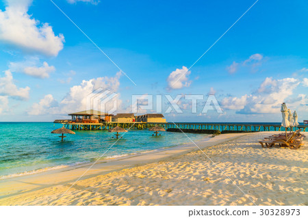 Beach chairs with umbrella at Maldives island, white sandy beach and sea . 30328973