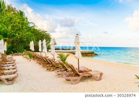 Beach chairs with umbrella at Maldives island, white sandy beach and sea . 30328974