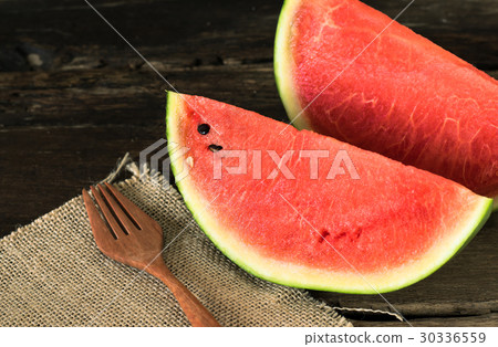 watermelon on a rustic wooden table with wood fork watermelon on a rustic wooden table with wood fork 30336559