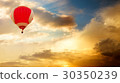 Hot Air Balloon Flying over Golden Sunset Sky 30350239