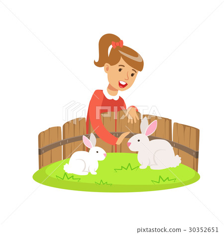 Smiling little girl petting two white rabbits in a Smiling little girl petting two white rabbits in a 30352651