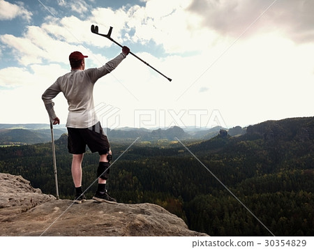 Man with leg in join immobilizer stay on summit Man with leg in join immobilizer stay on summit 30354829