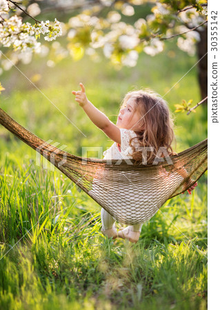 Child girl is having fun in hammock outdoors 30355142