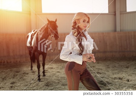 blonde girl standing near her horse 30355358