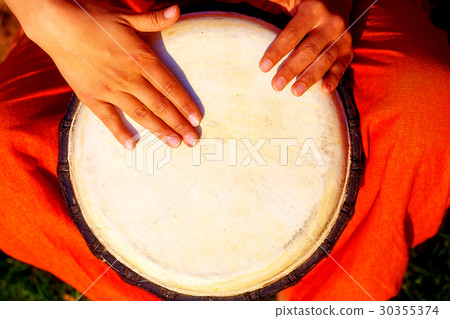 Young lady drummer with her djembe drum. 30355374