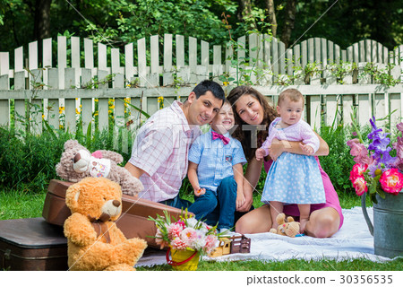 A couple sitting with the children A couple sitting with the children 30356535