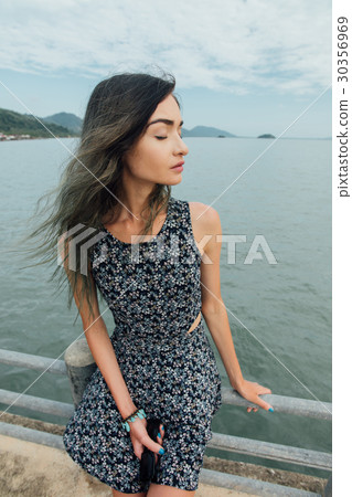 Young beautiful woman in dress sitting on the pier Young beautiful woman in dress sitting on the pier 30356969