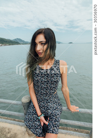 Young beautiful woman in dress sitting on the pier 30356970