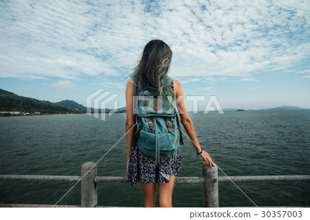 Girl in the dress is walking on the pier. Back 30357003