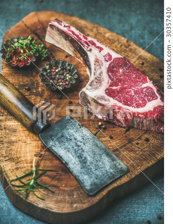 Dry aged raw beef rib eye steak with chopping Dry aged raw beef rib eye steak with chopping 30357410