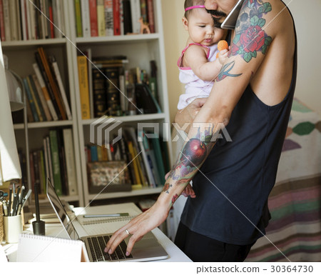 Dad Carrying His Baby and Busy Using Computer Laptop Dad Carrying His Baby and Busy Using Computer Laptop 30364730