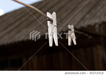 Old wooden clothespins for linen on the wire. Old wooden clothespins for linen on the wire. 30372418