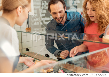 Excited man and woman choosing sweet pastry in 30372704