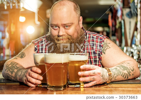 Cheerful bearded man placing glasses of beer 30373663
