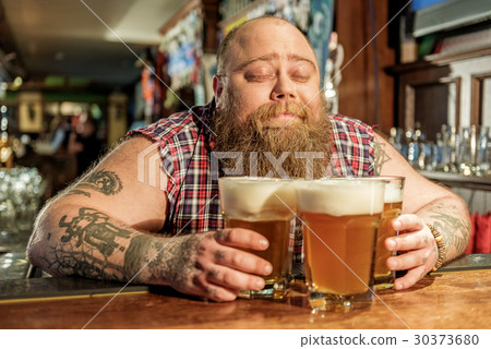 Glad fat man hugging alcohol in bar 30373680