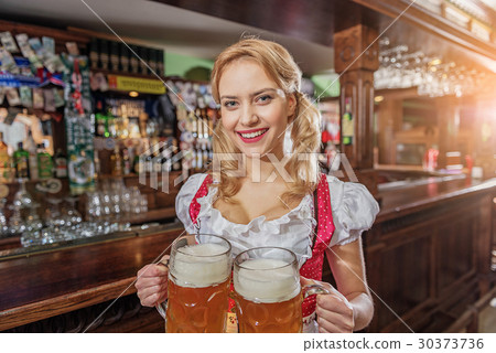 Cheerful female serving alcohol in pub 30373736
