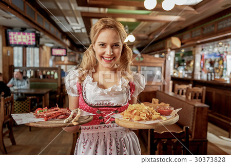 Outgoing girl holding order in pub 30373828
