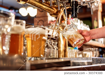 Man hand filling glass of alcohol beverage 30374380