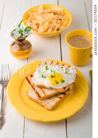 Toast with egg in yellow plate near vase Toast with egg in yellow plate near vase 30374604