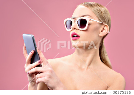 Attractive young woman looking at mobile screen Attractive young woman looking at mobile screen 30375156