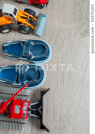 Blue boat shoes for boy near set of car toy 30375203