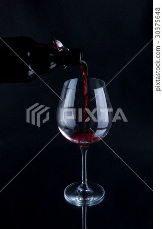 Red wine pouring into a wineglass 30375648